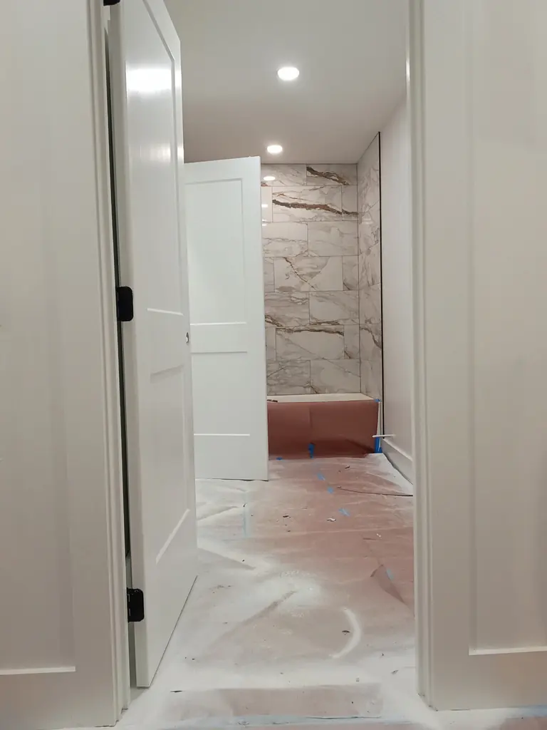 Large-format marble-look tile on bathroom walls in Knoxville, Tennessee