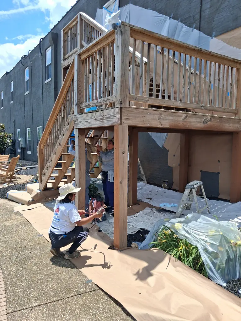 Crew staining a commercial deck and stair system in Lenoir City, Tennessee