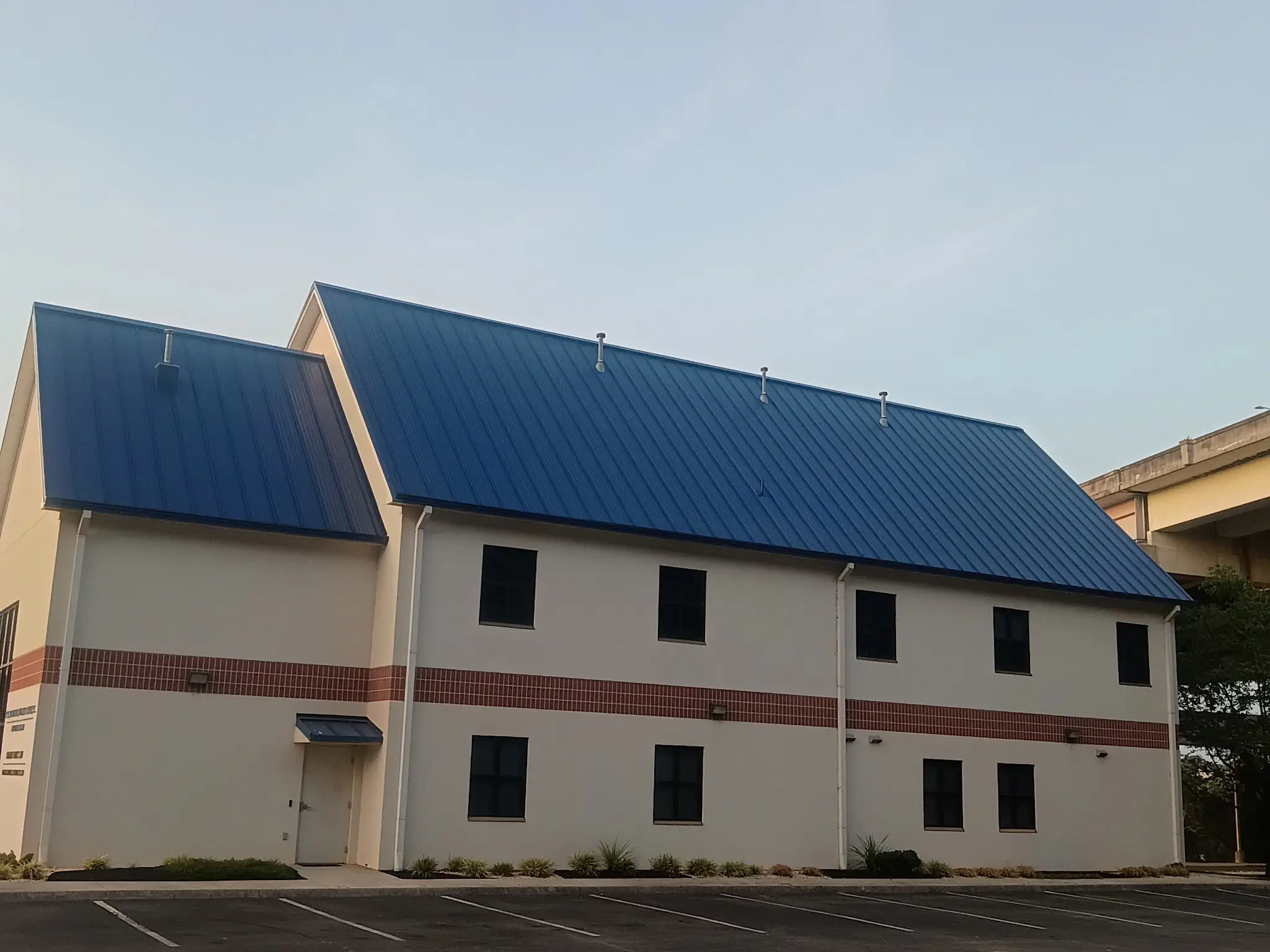 Commercial metal roof repainted deep blue in Knoxville, Tennessee